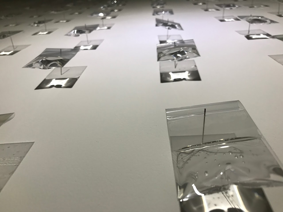 Reflective transparent elements suspended across an exhibition space